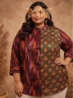 Woman modeling Boriby plus size kurta shirt with maroon ikat and green floral geometric motifs, standing against beige background.