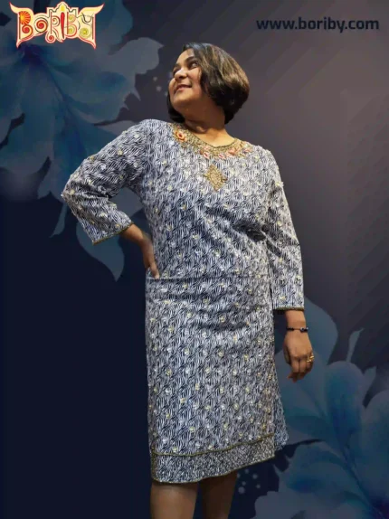 A woman wearing a navy‑blue cotton party dress with zebra print and intricate gold‑orange hand embroidery around the neckline, designed by Boriby.
