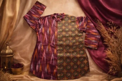 Close‑up of Boriby women’s magenta pure cotton ikkat and tissue silk shirt featuring dual patterns — maroon ikkat and geometric floral motif — with brass buttons and mandarin collar.