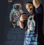 Person wearing Boriby oversized cotton T‑shirt with astronaut space graphic and Bengali typography, selfie with matching background design