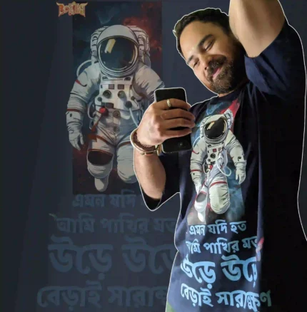 Person wearing Boriby oversized cotton T‑shirt with astronaut space graphic and Bengali typography, selfie with matching background design