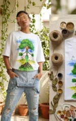 Boriby biophilic hand‑painted white T‑shirt with tree and human design, styled with denim overalls and eco‑friendly art supplies.