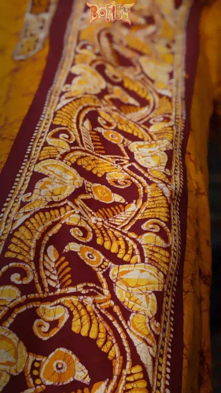 Close‑up of maroon batik cotton fabric with cream floral motifs