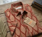 Folded Boriby Ajrakh Printed Half Shirt with artisan motifs on wooden surface
