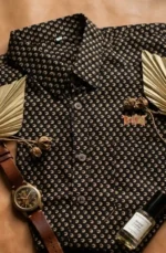 Black Boriby Ajrakh Printed Half Shirt with beige motifs styled with watch, perfume, and palm leaves in flat lay