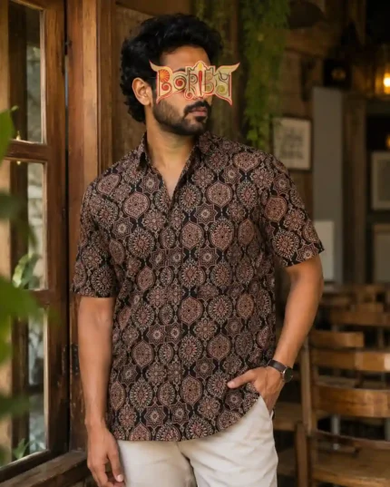 Man in Ajrakh printed half shirt with light pants in rustic indoor setting